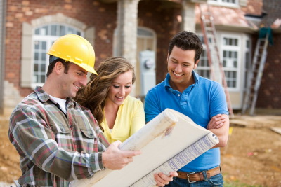 Construction: Young Couple Look At Home Plans with Builder.
